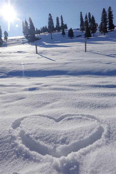 Close Up Shot Of Heart Shape In Pure White Winter Snow Stock Photo