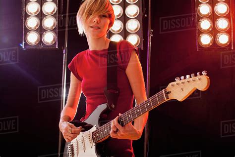 A Woman Playing Electric Guitar Performing On Stage Stock Photo