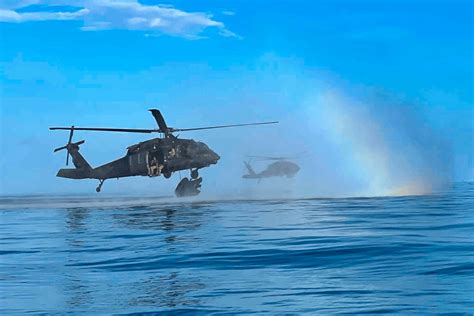 A Uh 60 Black Hawk Helicopter Deploys A Raiding Craft During A