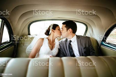 Hispanic Newlyweds Kissing In The Backseat Stock Photo Download Image