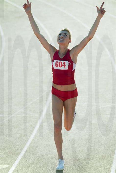 Young Woman Runner Completing Race With Arms Raised Y