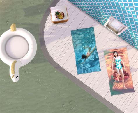 An Aerial View Of A Pool With Towels And Pictures On The Table Next To It
