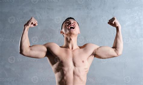 Muscular Asian Man Posing On Gray Background Stock Photo At Vecteezy