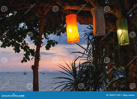 Sunset On An Island Beach With Lanterns Illuminating The Romantic Scene