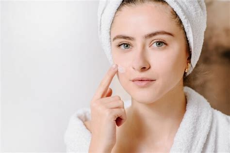 Premium Photo Face Cream Woman In Bathrobe With A Towel On Her Head