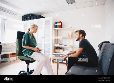 Female Nurse Talking With Male Patient In Office Stock Photo Alamy