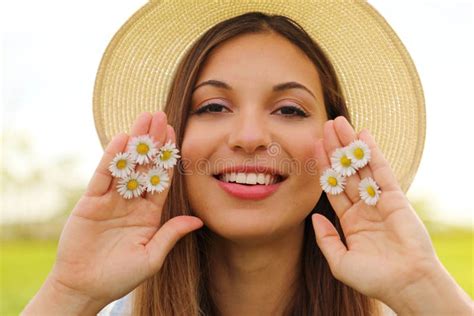 Close Up Portrait Of Spring Girl With Hat Holds Between Fingers Daisies