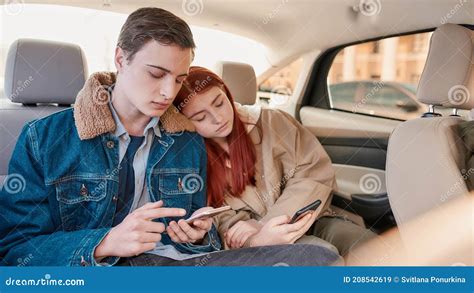 A Couple Of Teenagers Looking Tired Using Their Smartphones While