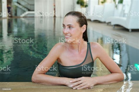 Happy Brunette Girl In Dark Green Swimsuit Relaxing In Swimmingpool