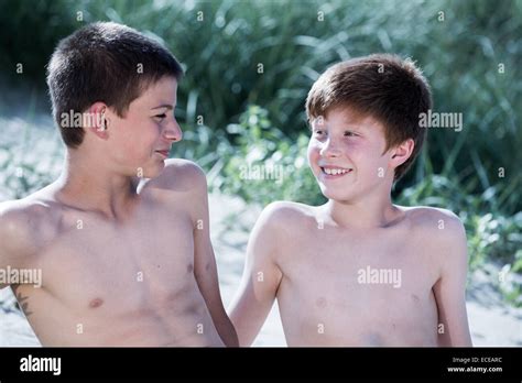 Dos muchachos sentados en la playa mirando Fotografía de stock Alamy