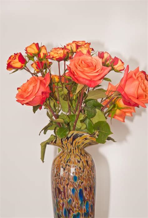 Ceramic Vase Filled With Four Long Stemmed Orange Roses And A Dozen