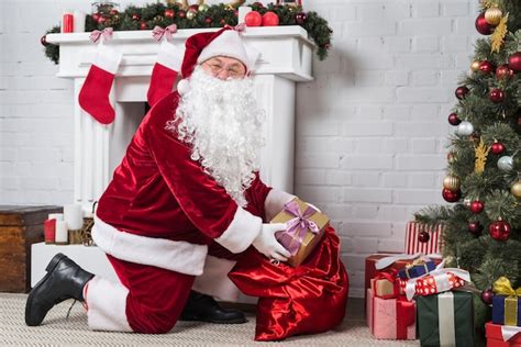 Free Photo Santa Putting Gifts Under Decorated Christmas Tree