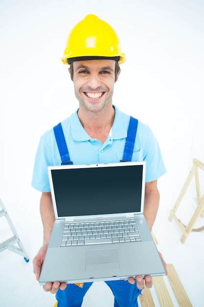 Premium Photo Happy Repairman Wearing Hard Hat While Holding Laptop