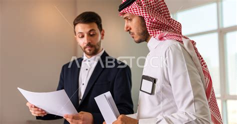 رجل اعمال سعودي خليجي في مقر الشركة مع السكرتير الخاص فيه يدير المهام اليومية ،ادارة الاعمال