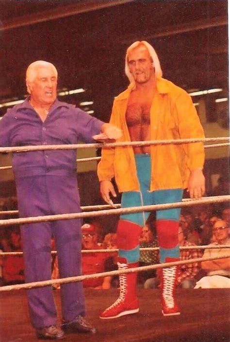 Two Men Standing Next To Each Other In A Wrestling Ring