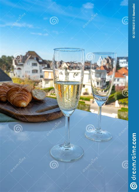 Drinking Of Brut Champagne Sparkling Wine In Flute Glasses On Outdoor Bistro Terrace In France