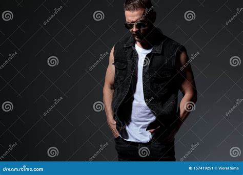 Thoughtful Young Man Looks Down With Hands In Pockets Stock Image