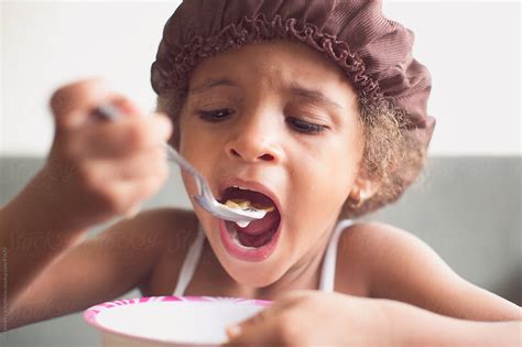 A Young Girl Having A Bowl Of Cereal For Breakfast By Stocksy