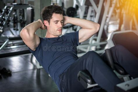 Handsome Man Exercising Doing Sit Up Abdominal Exercise In Gym Stock