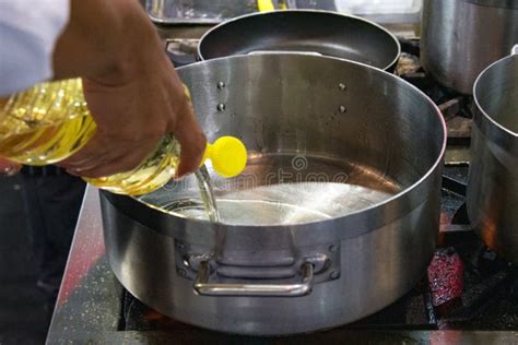 Woman Pouring Cooking Oil From Bottle Into Frying Pan Stock Photo