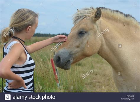 Teenage Girl Strokes The Head Of A Pony Holmsland Klit West Jutland