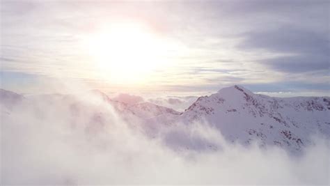 Aerial Drone Flight Over Mountain Range Through Clouds At