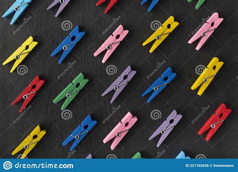 Top View Of Bright Multi Colored Clothespins On Black Background
