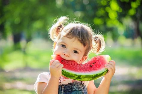 Premium Photo A Child Eats Watermelon Selective Focus