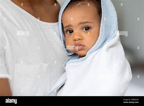 Portrait Of Cute Black Infant Child Wrapped In Blue Hooded Bath Towel