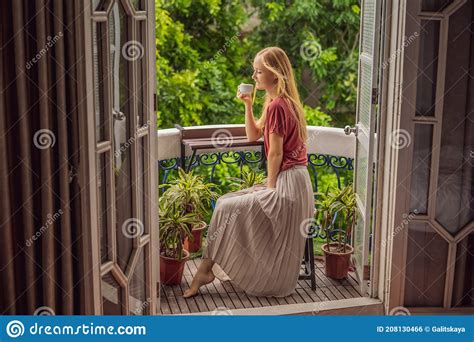 A Ginger Haired Woman Stands On A Heritage Style Balcony Enjoying Her