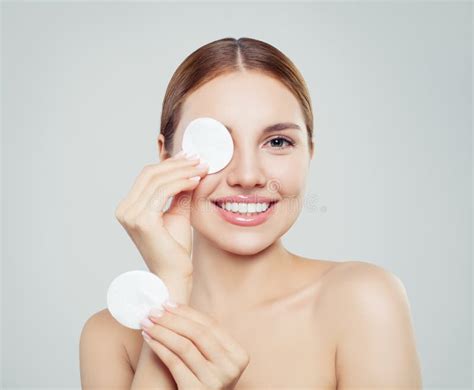 Cheerful Woman Removing Face Makeup With A Cotton Pad Stock Photo