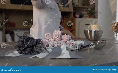Confectioner Sprinkling Powdered Sugar On Pink Marshmallows On The