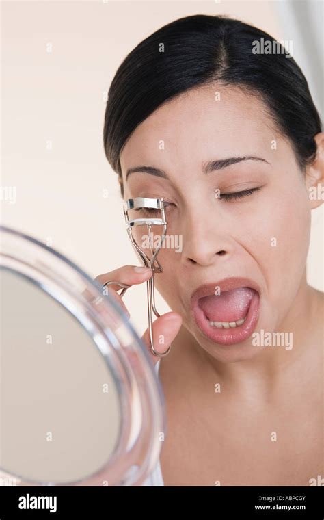 Woman Curling Her Eyelashes Stock Photo Alamy