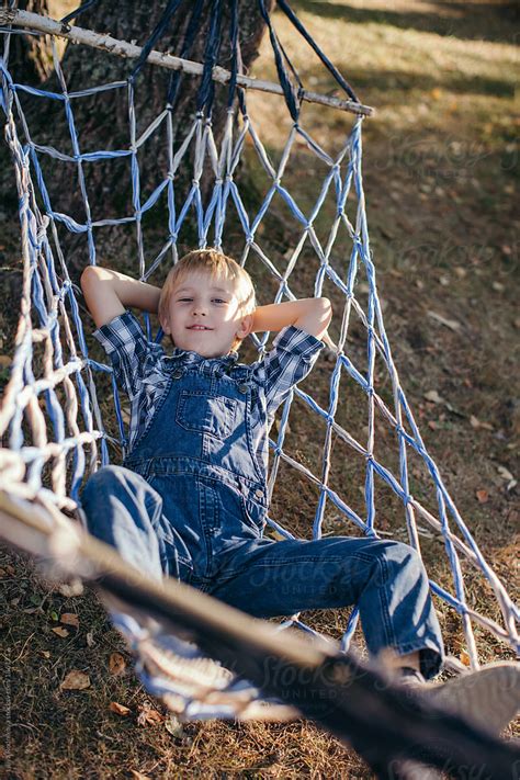 Cute Blond Boy Laying At Hammock Outdoors By Stocksy Contributor
