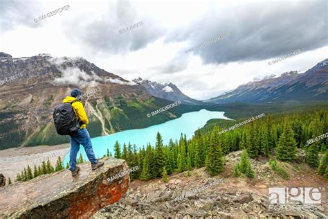 Hiker Looking Into The Distance View Of Turquoise Glacial Lake