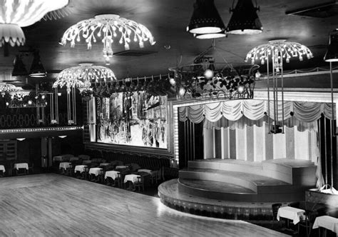 An Old Black And White Photo Of A Stage With Chandeliers Hanging From