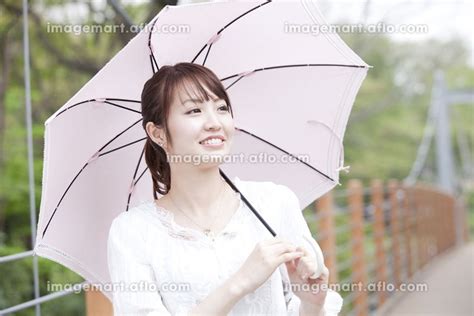 傘を差して歩く女性 24009036 ｜イメージマート