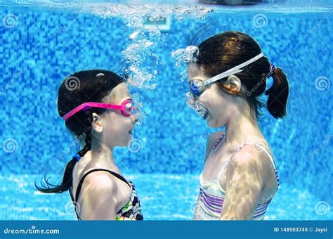 Children Swim In Swimming Pool Underwater Happy Active Girls Have Fun