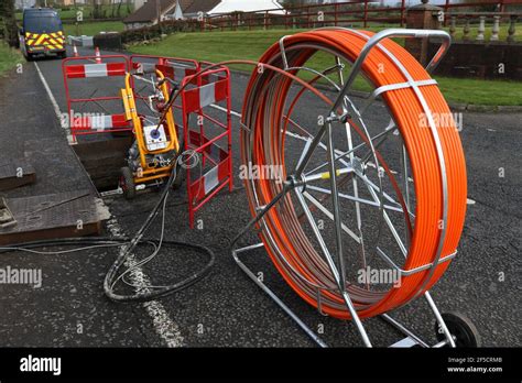 A Reel Of Fiber Optic Cable Is Fed Into A Manhole During The