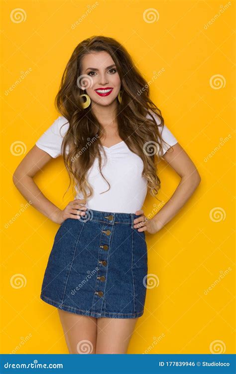 Smiling Casual Young Woman In Jeans Mini Skirt Is Posing With Hands On