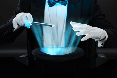 Magician Holding Magic Wand Over Illuminated Hat Stock