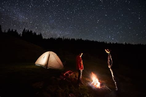 Premium Photo Tourists Near Campfire And Tent Under Night Starry Sky