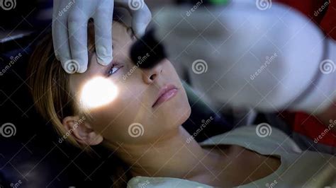Paramedic Shining Light Into Patient Eyes Testing Pupil Reflexes