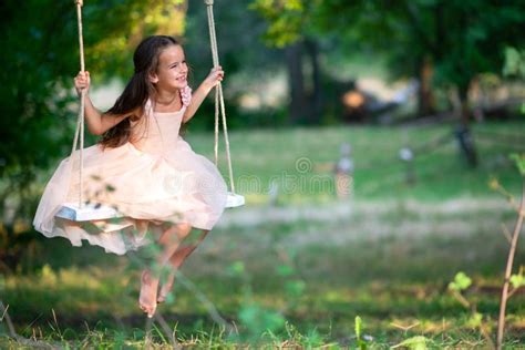 Happy Girl Rides On A Swing In Park Little Princess Has Fun Outdoor Summer Nature Outdoor