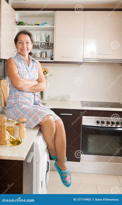Mature Woman Sitting At Kitchen Stock Photo Image Of Bright Casual
