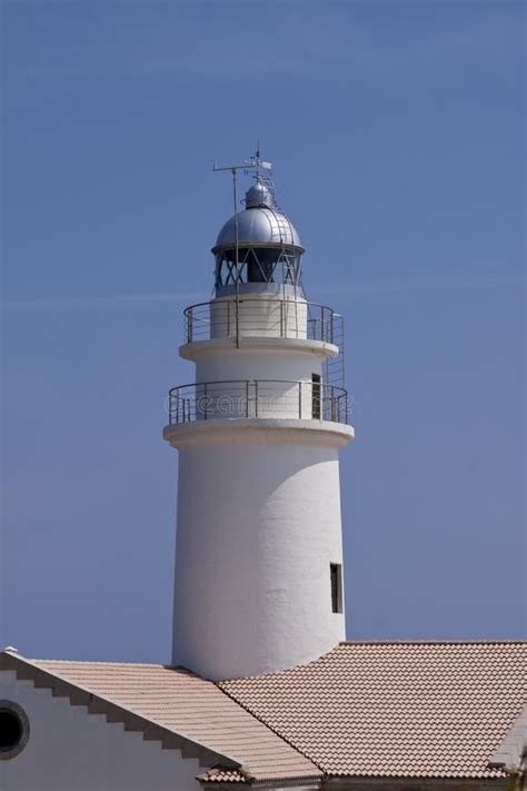 White Lighthouse On Rocks In The Sea Ocean Water Sky Blue Stock Image