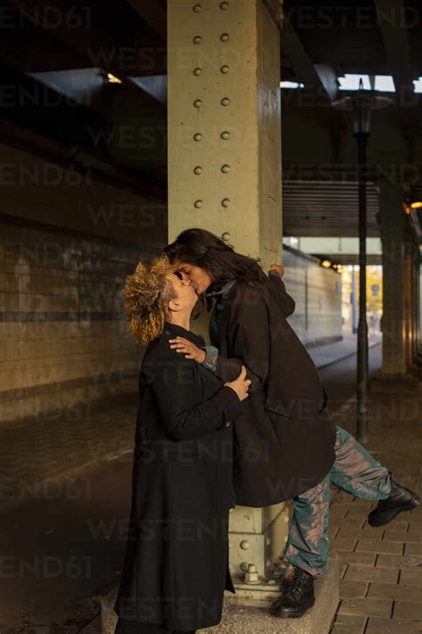 Lesbische Paar Küssen Unter Brücke In Der Nacht Lizenzfreies Stockfoto