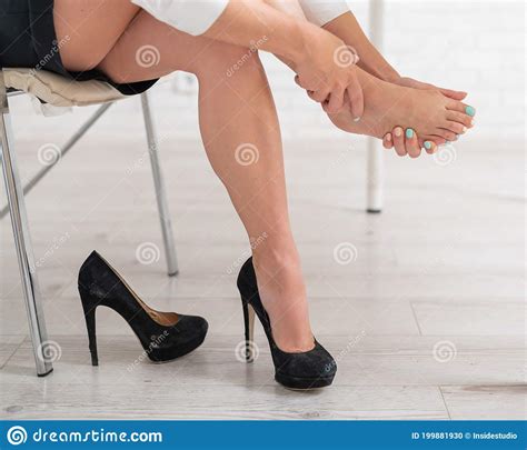 Business Woman Took Off Her Black High Heeled Shoes And Massages Her Feet Ankle Pain From