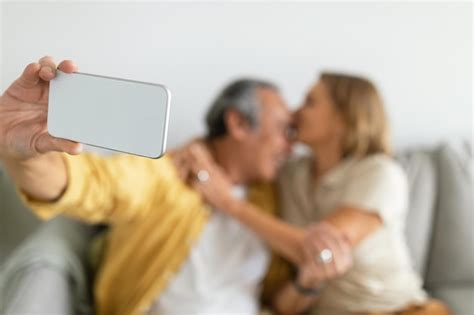 premium photo loving aged caucasian wife kissing husband man making selfie on smartphone