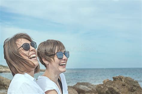 twee gelukkige glimlachende meisjes op het strand sensatie van vreugde tussen twee vrienden
